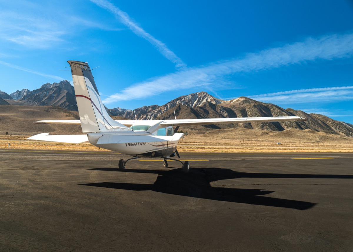 Avión pequeño en pista remota junto a la cordillera